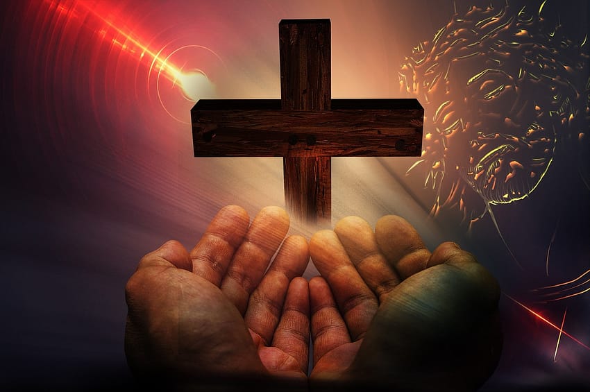 wooden cross with a pair of open hands in front of it.